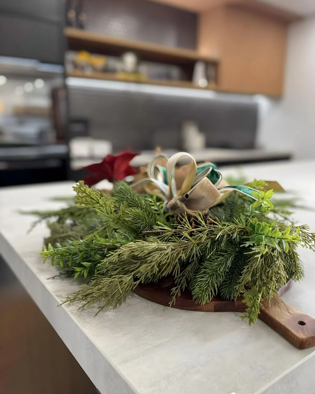 Styled kitchen island with a decorative Christmas wreath placed on the benchtop, adding a festive touch to the display