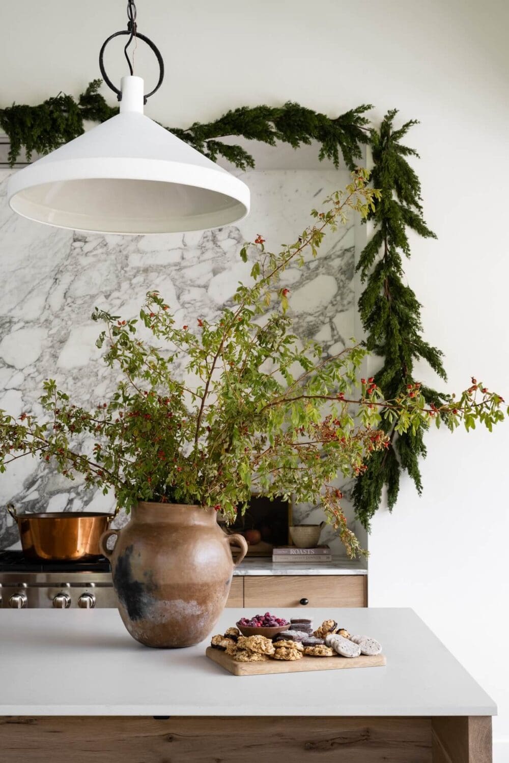 Studio McGee–style kitchen featuring a festive garland draped across the upper cabinets.