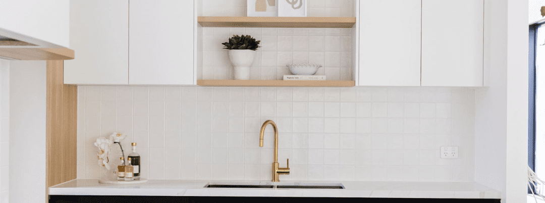 Minimalist butler's pantry with gold tap, open shelves, and white tiled splashback