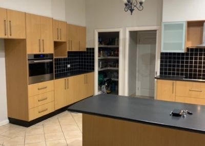 Before kitchen renovation shot of old timbre kitchen with black countertops