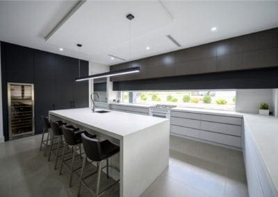 sleek streamlined stunning two toned kitchen Kirkham wide shot with integrated wine fridge cabinetry