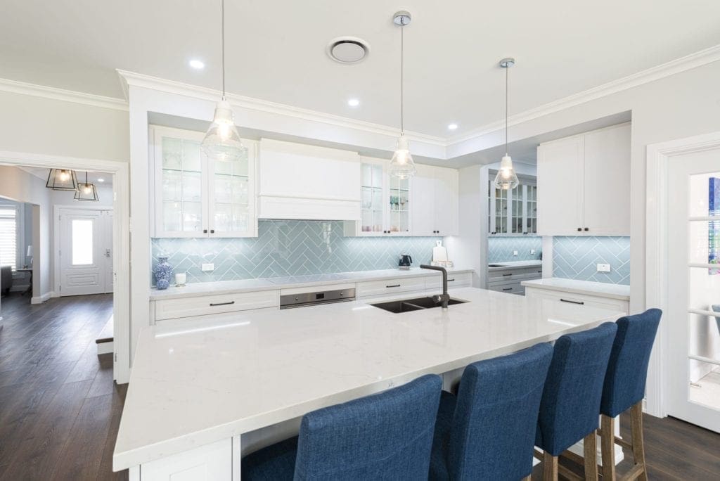 Modern contemporary kitchen with light blue hues wide shot with butlers pantry