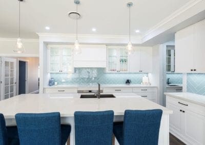 Modern contemporary kitchen with light blue hues wide shot with butlers pantry