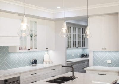 Modern contemporary kitchen with light blue hues light pendants