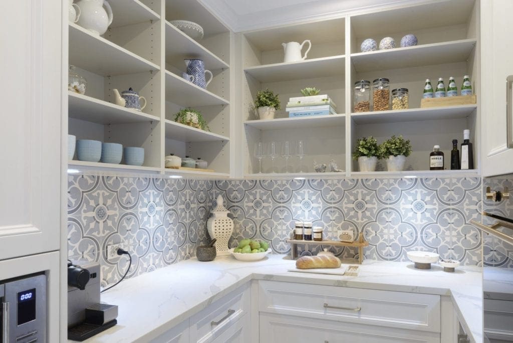 Elegant butler's pantry with open shelving, patterned splashback, and marble benchtops