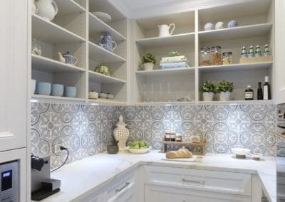 Elegant butler's pantry with open shelving, patterned splashback, and marble benchtops