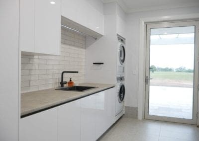 Modern white kitchen Razorback laundry with subway tile splashback