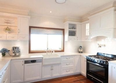 traditional kitchen with white provincial-style cabinets and custom painted mantle rangehood