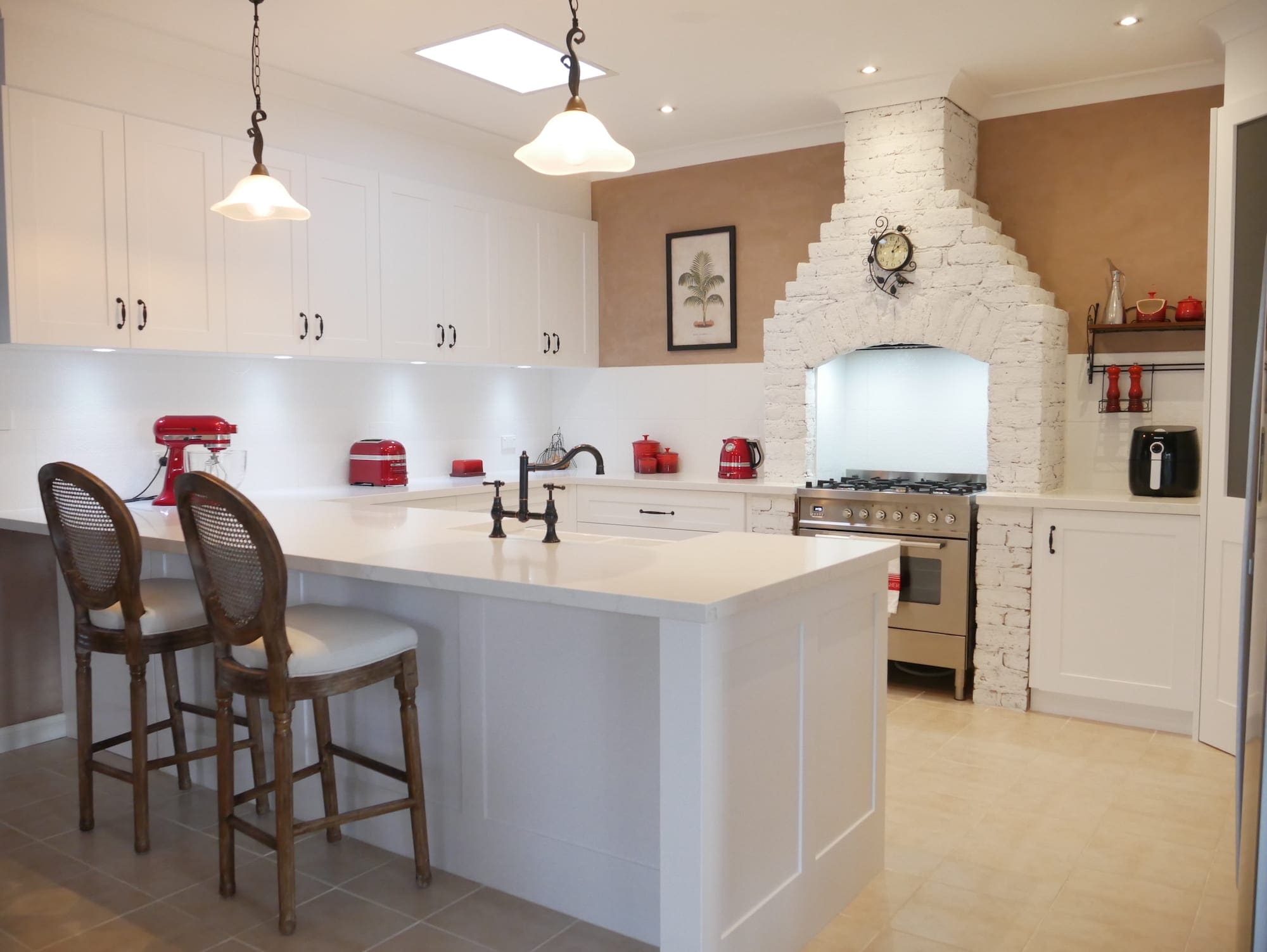 Character country filled kitchen in Mittagong white cabinetry with red appliances