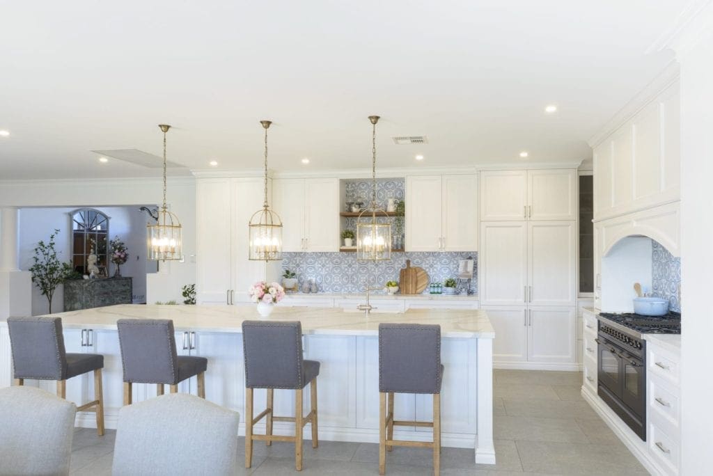 Light antique luxury kitchen with tiled splashback Kirkham bar stools and large kitchen island wide shot