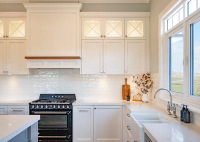 breathtaking two toned hamptons style kitchen exeter with white cabinetry and black appliances