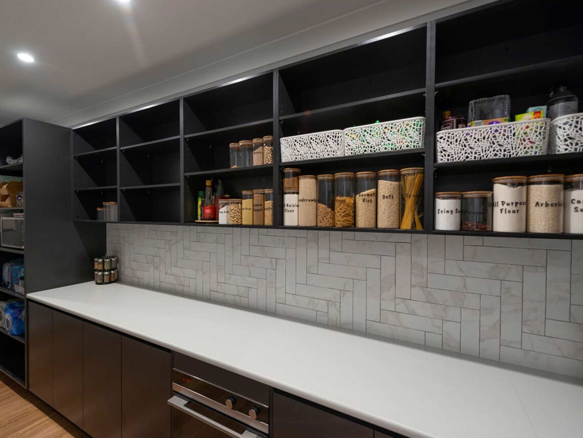 marble splashback tile in straight herringbone style for kitchen splashback tile surrounded by dark cabinets