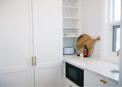 Stylish butler's pantry with white cabinetry, marble benchtop, and modern appliances
