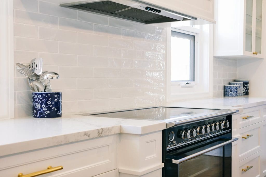glamorous and bold two toned hamptons kitchen shell cove cooktop and rangehood