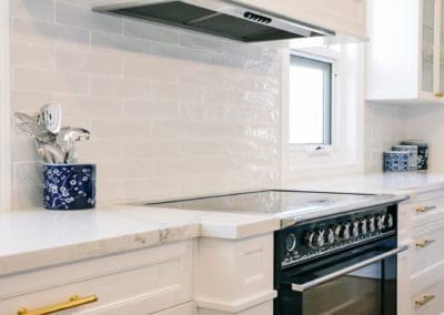 glamorous and bold two toned hamptons kitchen shell cove cooktop and rangehood