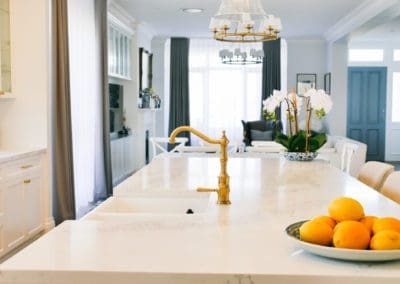 glamorous and bold two toned hamptons kitchen shell cove stone benchtop and gold tapware