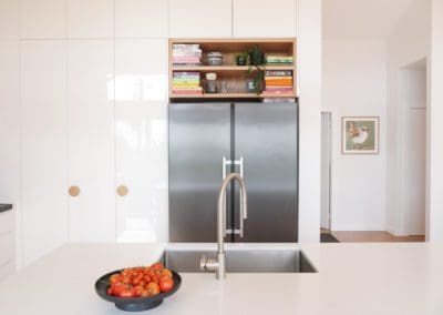 Gloss doors complement the polished Quantum Quartz Michelangelo benchtops, featuring a 40mm thickness at the back and 60mm on the island with waterfall ends.