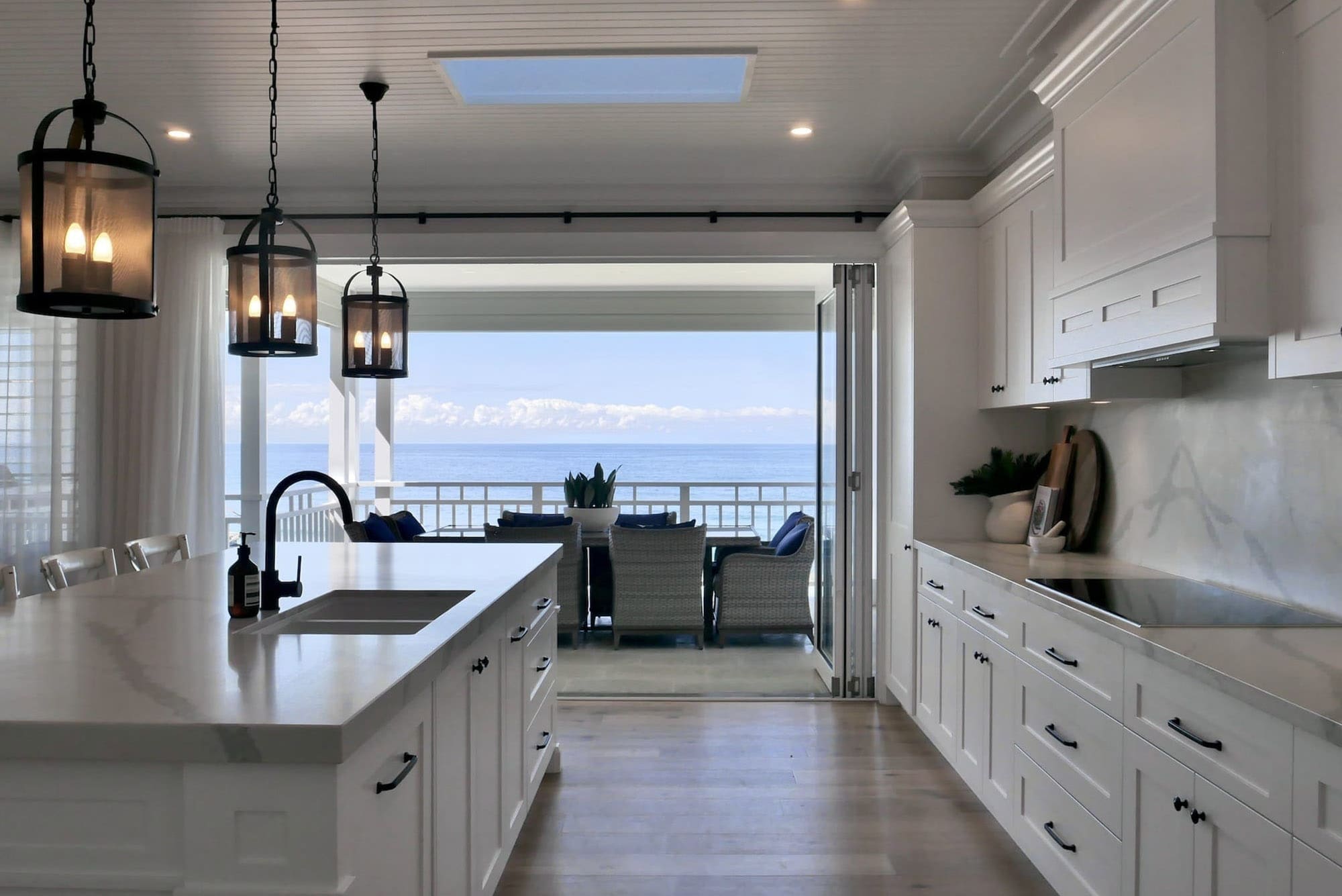Luxury kitchen renovation in Wombarra, Sydney — modern ocean-inspired design with sweeping coastal views from the balcony.