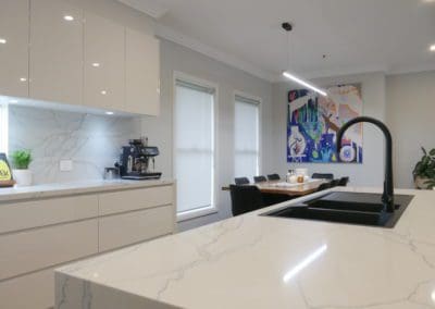 streamlined sophisticated kitchen mount annan kitchen island benchtop with colourful artwork in the background