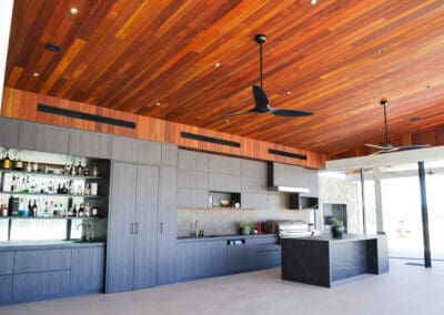 Industrial style kitchen with dark cabinetry, timber ceiling, and modern finishes