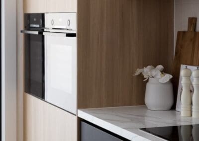 The bottom cabinetry features Tesrol Superclean in Carbon, adding a dramatic finish that complements the warmth of the timber.