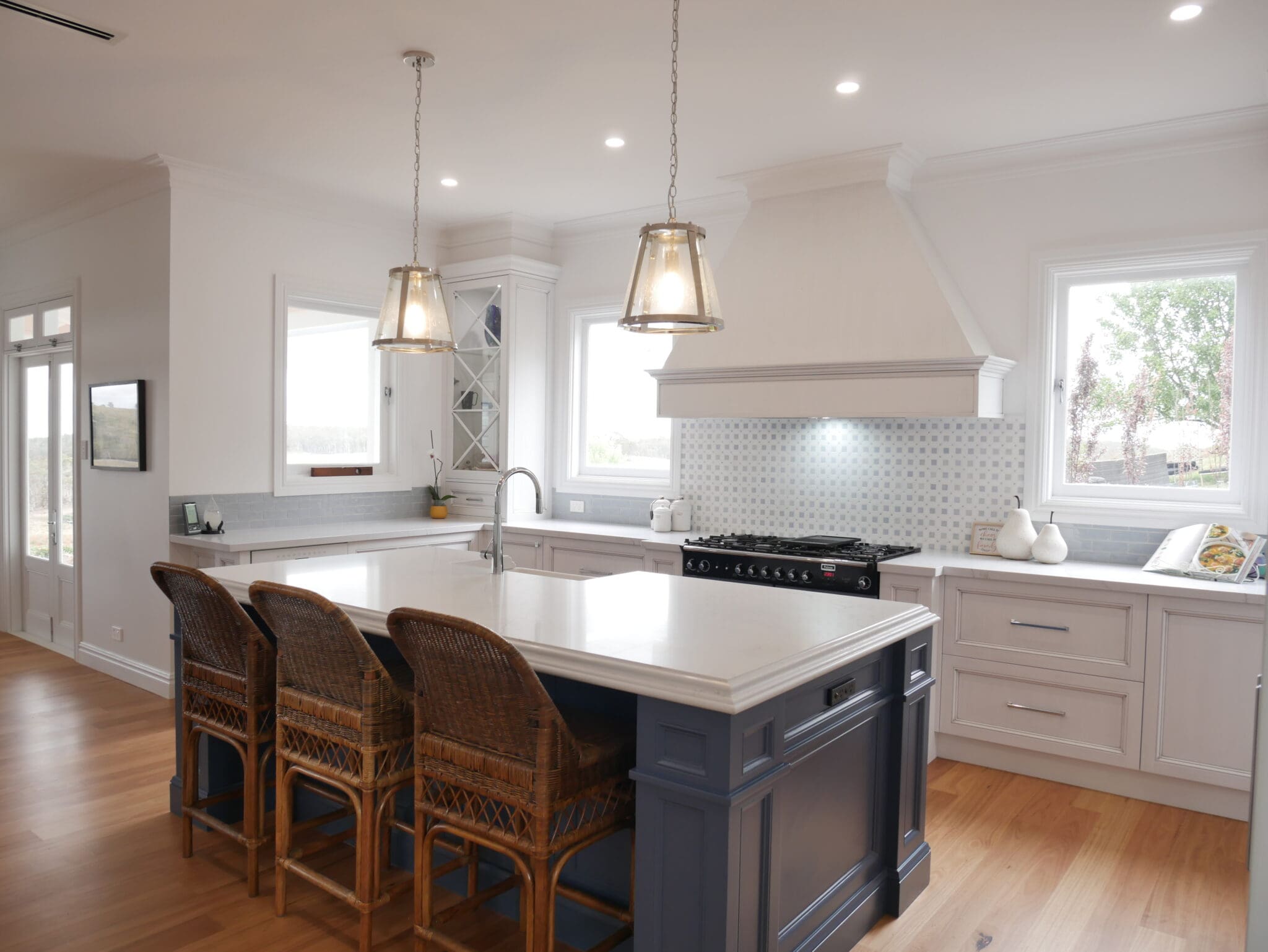"A stunning medium antiqued hand-painted finish on the kitchen cabinetry, with Dulux Lexicon quarter strength over the rich Dulux Domino. The island is colour-matched to the blue of the client’s Falcon cooker. In the butler’s pantry, Dulux Lexicon quarter strength in a satin finish adds a touch of glamour.