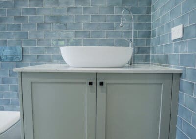 The vanity is colour-matched in a satin finish, featuring YDL Angel Falls with a 20mm edge. Glossy kit kat wall tiles add a perfect glamorous touch.