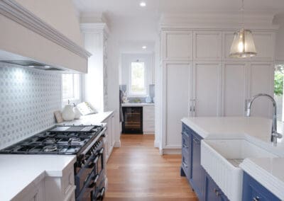 The kitchen cabinetry features a stunning medium antiqued hand-painted finish, with Dulux Lexicon quarter strength over the rich Dulux Domino. The island is colour-matched to the blue of the client’s Falcon cooker.