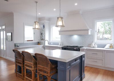 Natural light opens up the kitchen, illuminating the stunning medium antiqued hand-painted cabinetry, with Dulux Lexicon quarter strength over the rich Dulux Domino. The island is colour-matched to the blue of the client’s Falcon cooker.