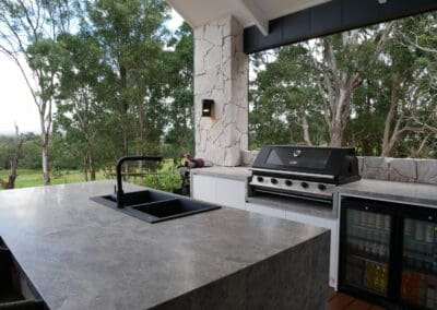 Tundra Grey limestone benchtops and island complement the rustic wall cladding.