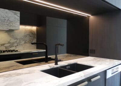 The bar side of the kitchen, oriented towards the view, enhances the glamour with a full Calacatta Vagili marble splashback.