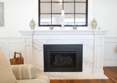Fireplace with a stunning mantle and base made of Precious White honed marble, adding luxurious warmth to the space.
