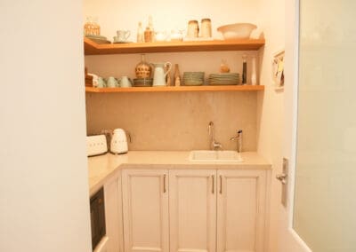Hidden butlers pantry with a second Turner Hastings drop-in sink, microwave, and American White Oak timber shelving, adding warmth to the space.