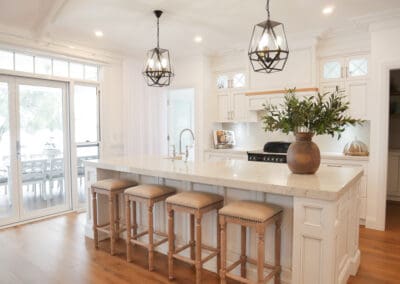 The elegance of Caesarstone Bianco Drift, with 40mm mitred edges and 60mm on the island, enhances the kitchen’s sophisticated design. The striking black glass and metal pendants, suspended on either side of the island, provide a bold finishing touch. Dulux Lexicon quarter strength paired with Dulux Domino creates a stunning contrast, while the traditional profile and proud island kicks, matched to the skirting boards, elevate the overall luxurious feel throughout the home.