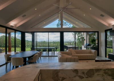 Luxury open-plan living and dining space with cathedral ceiling, marble kitchen island, and panoramic views in Cobbitty.