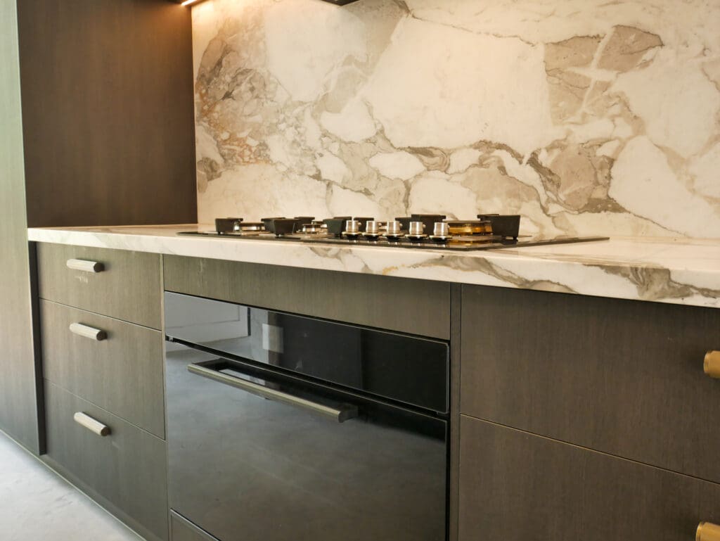 Dark Ilve oven and gas cooktop with a full Calacatta Vagili marble splashback