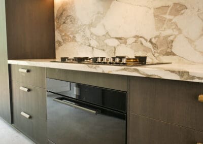 Dark Ilve oven and gas cooktop with a full Calacatta Vagili marble splashback