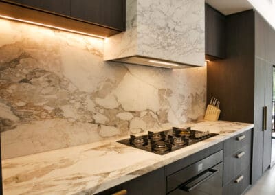 Dark Ilve oven and gas cooktop with a full Calacatta Vagili marble splashback on the bar side of the kitchen, focusing on glamour and the stunning view.