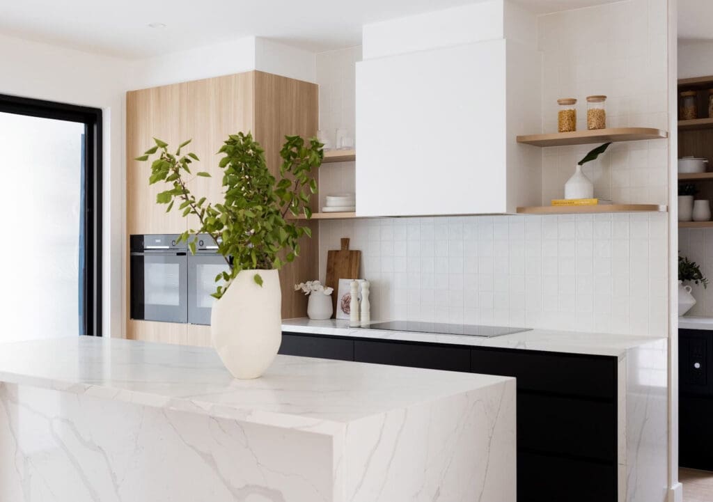 Contemporary kitchen featuring Dulux Lexicon quarter strength matte cabinetry, Polytec Plantation Ash woodmatt accents, and Tesrol Superclean Carbon bottom cabinetry. Modern square finger pull drawers and flat doors, with a hidden butler’s pantry.