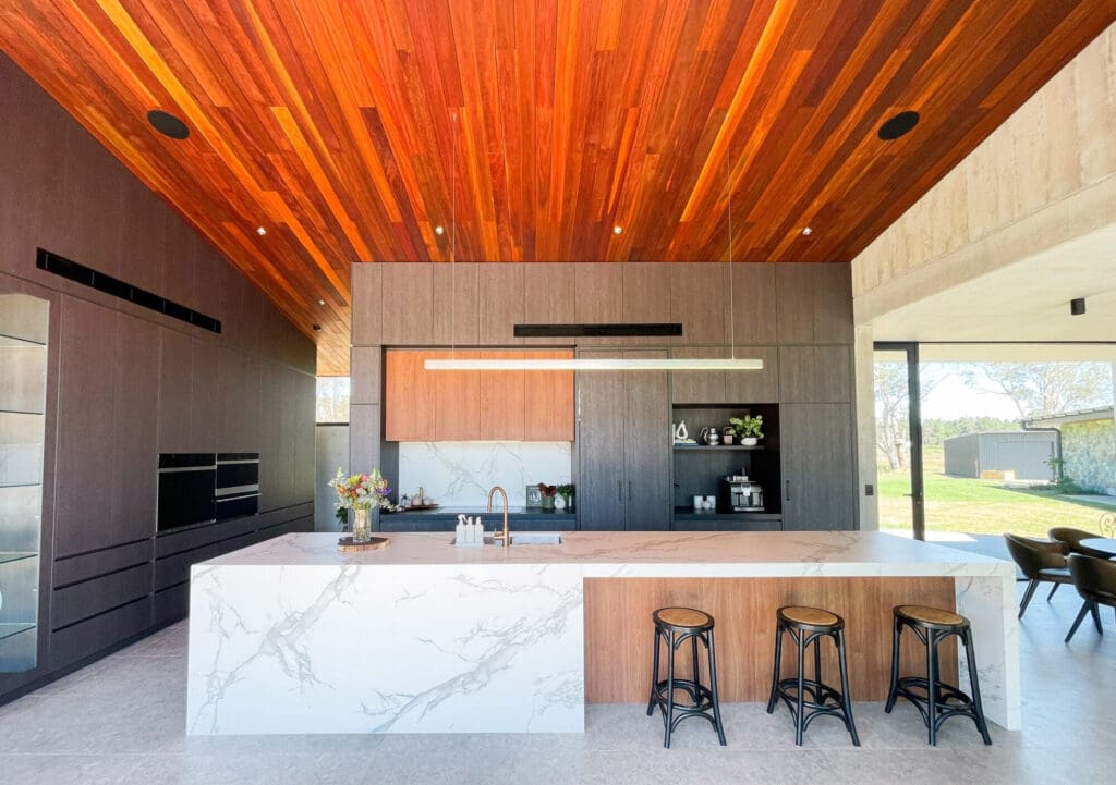 Two-toned kitchen with soaring ceilings featuring Dekton Sirius porcelain benchtops.