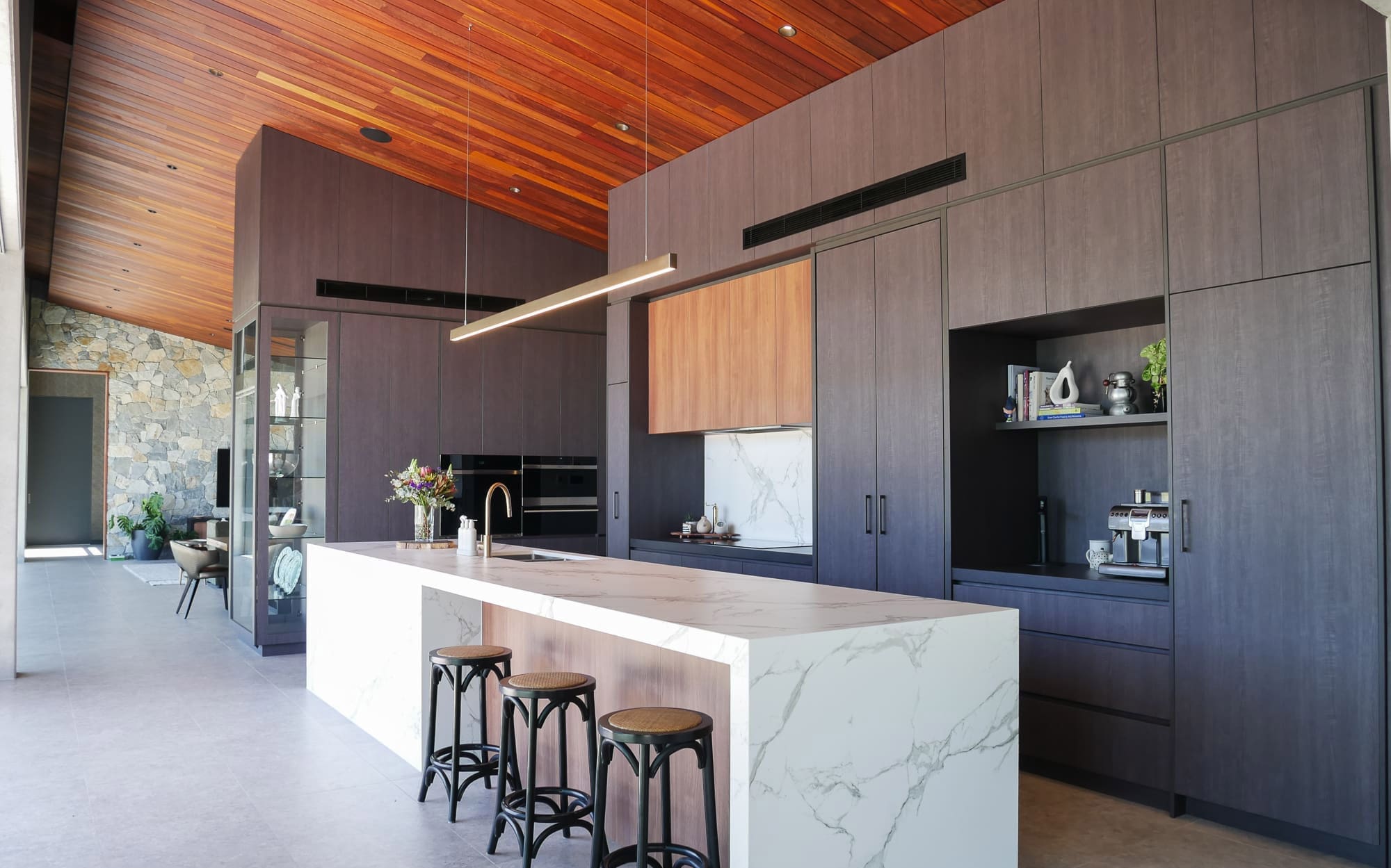 Black kitchen with matt finishes and a sleek island bench for a modern industrial look