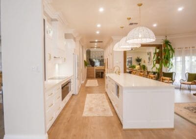 Cabinetry in Dulux Lexicon ¼ strength matte finish with Hamptons profile, complemented by YDL Stone 'Vene Rose' benchtops and splashbacks featuring subtle taupe veining and creamy undertones, enhancing the warmth of the surrounding timber.