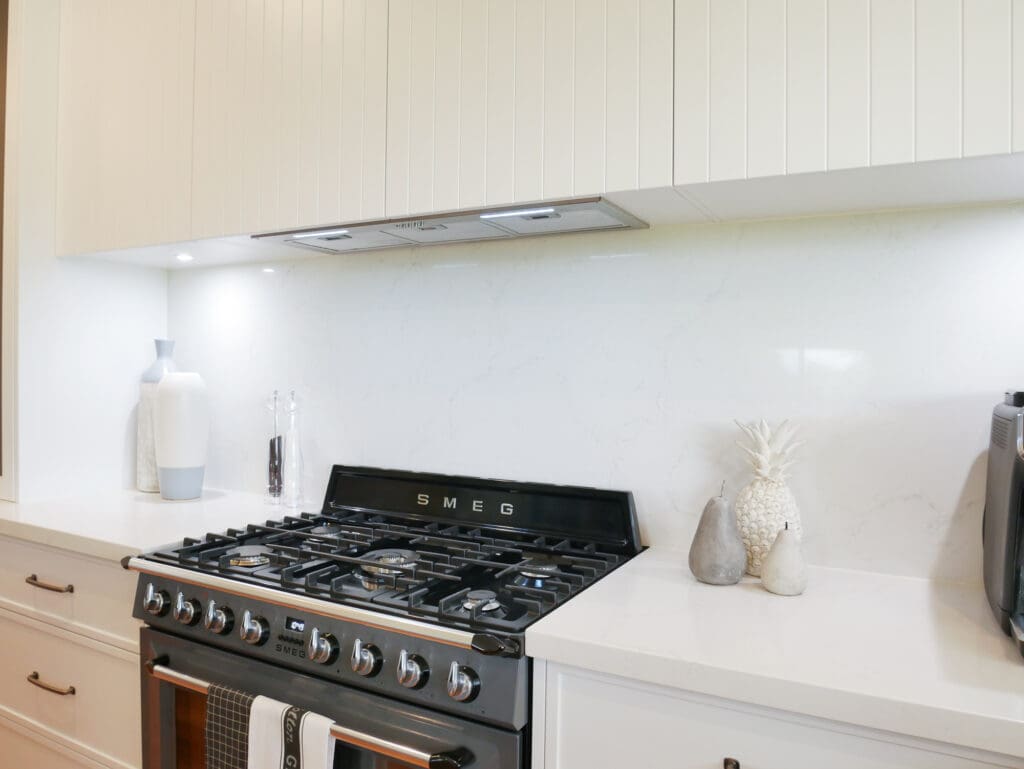 Modern Hamptons-style kitchen with a gas stove and Kitchen Under Counter Lights illuminating a white splashback.
