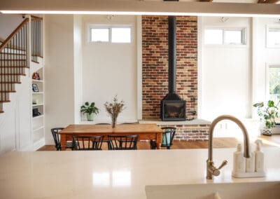 A Turner & Hastings double butler's sink centered on the kitchen island, with a traditional polished nickel mixer tap matching the kitchen knobs and Momo New Hampton cup handles.