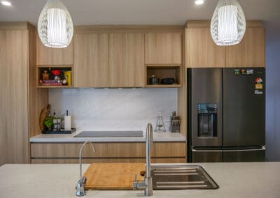A modern kitchen island featuring an Abey double sink with matching stainless steel taps, including a Gareth Ashton gooseneck pull-out mixer tap, adding a contemporary touch to the space.