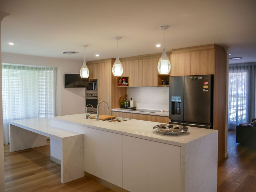 Contemporary two-toned kitchen featuring YDL Stone kitchen island bench, timber cabinetry, and modern pendant lighting.