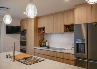 Wall cabinetry featuring Polytech Plantation Ash, adding natural texture and style to the space. The cabinet doors are handle-free, designed with a push-to-open feature for a sleek, elegant, and functional look.