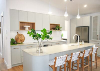 Modern open-plan kitchen with sleek cabinetry and island seating, showcasing a stylish renovation that reflects smart kitchen renovation costs.