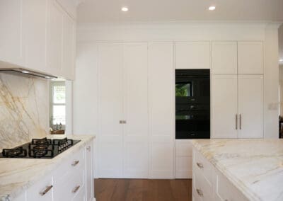 Modern kitchen featuring quality kitchen cabinets with a sleek, white finish and brushed metal handles.