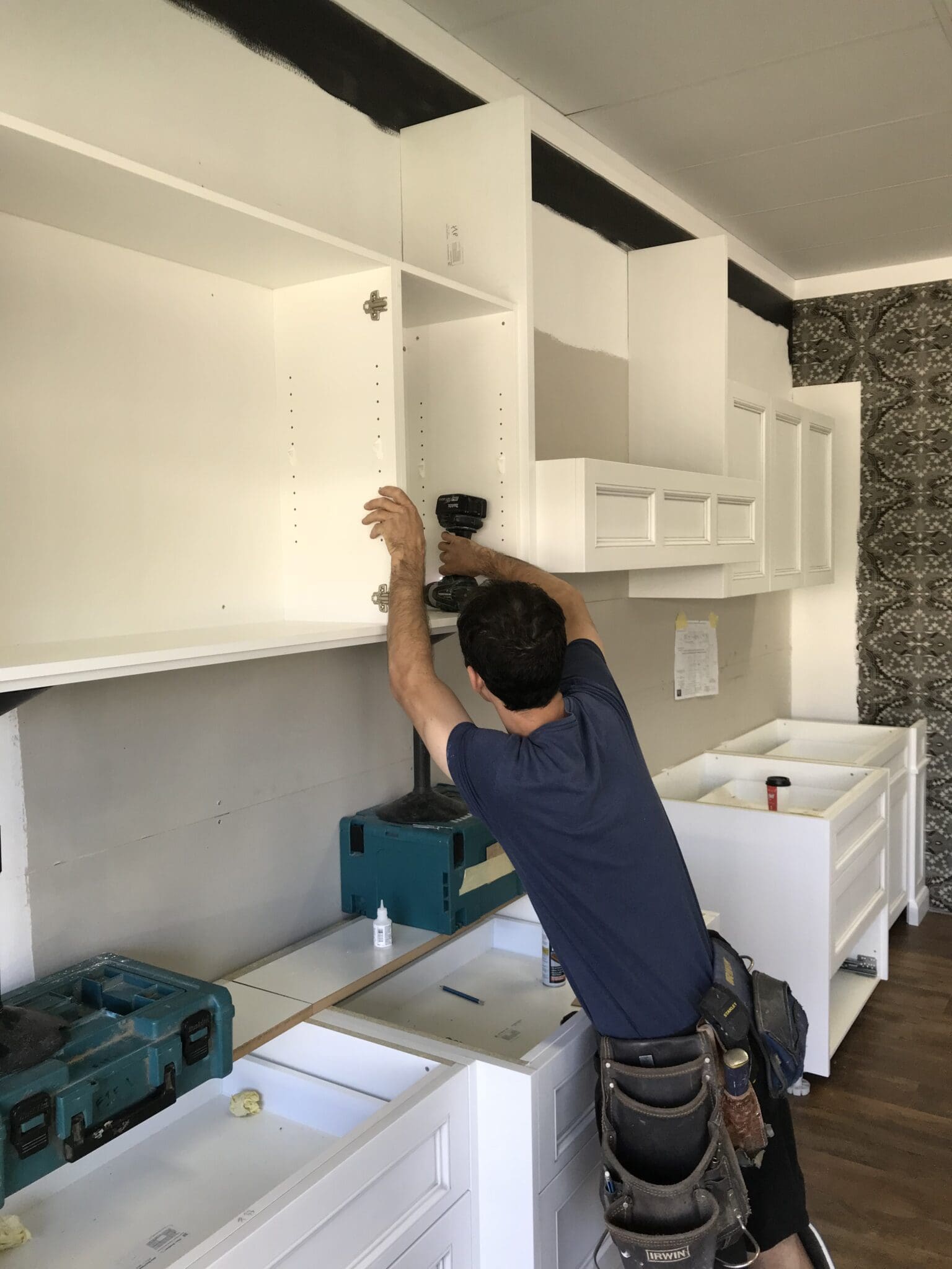 typical kitchen renovation with a tradesman installing the cabinets